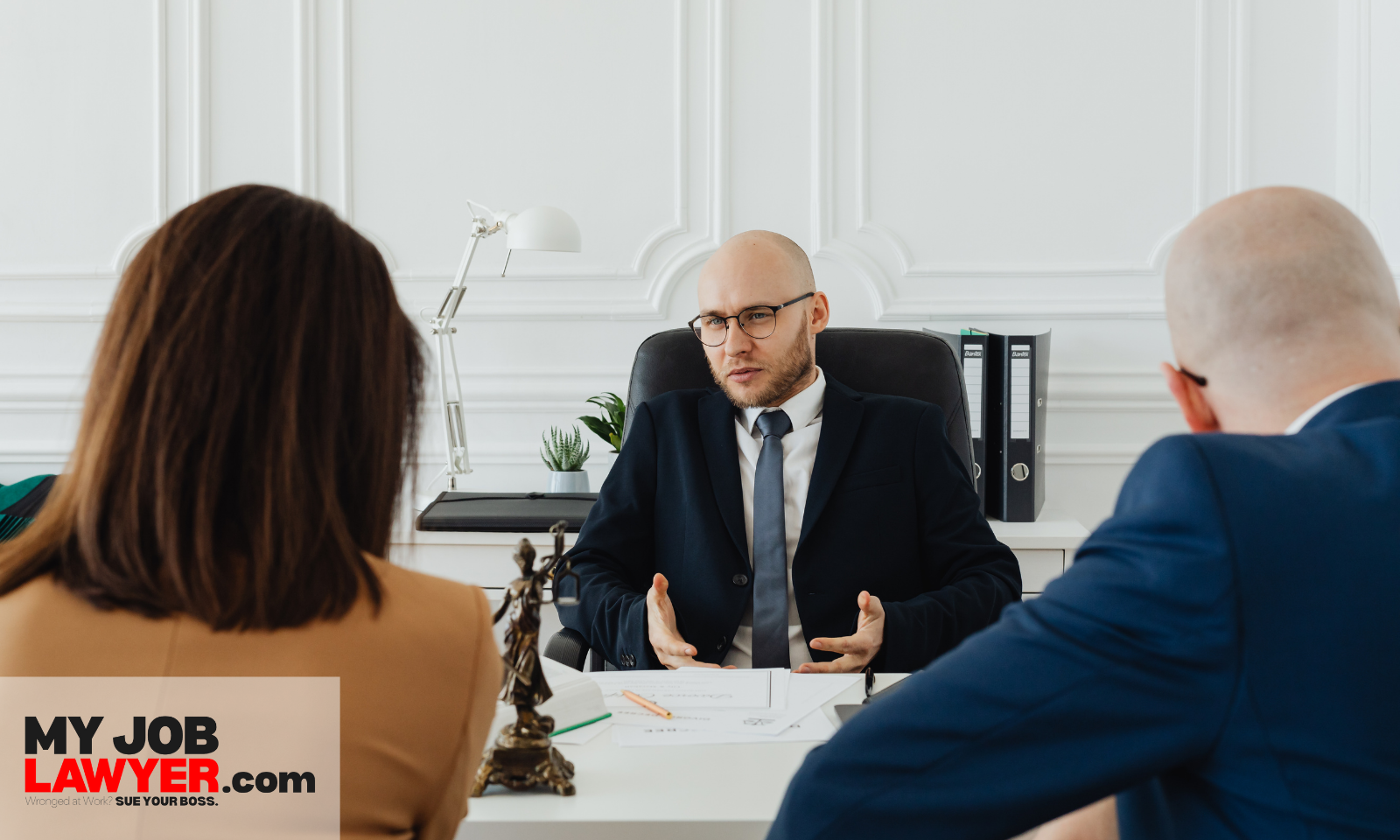 Lawyer consulting with clients about the average settlement for retaliation lawsuit and possible compensation.