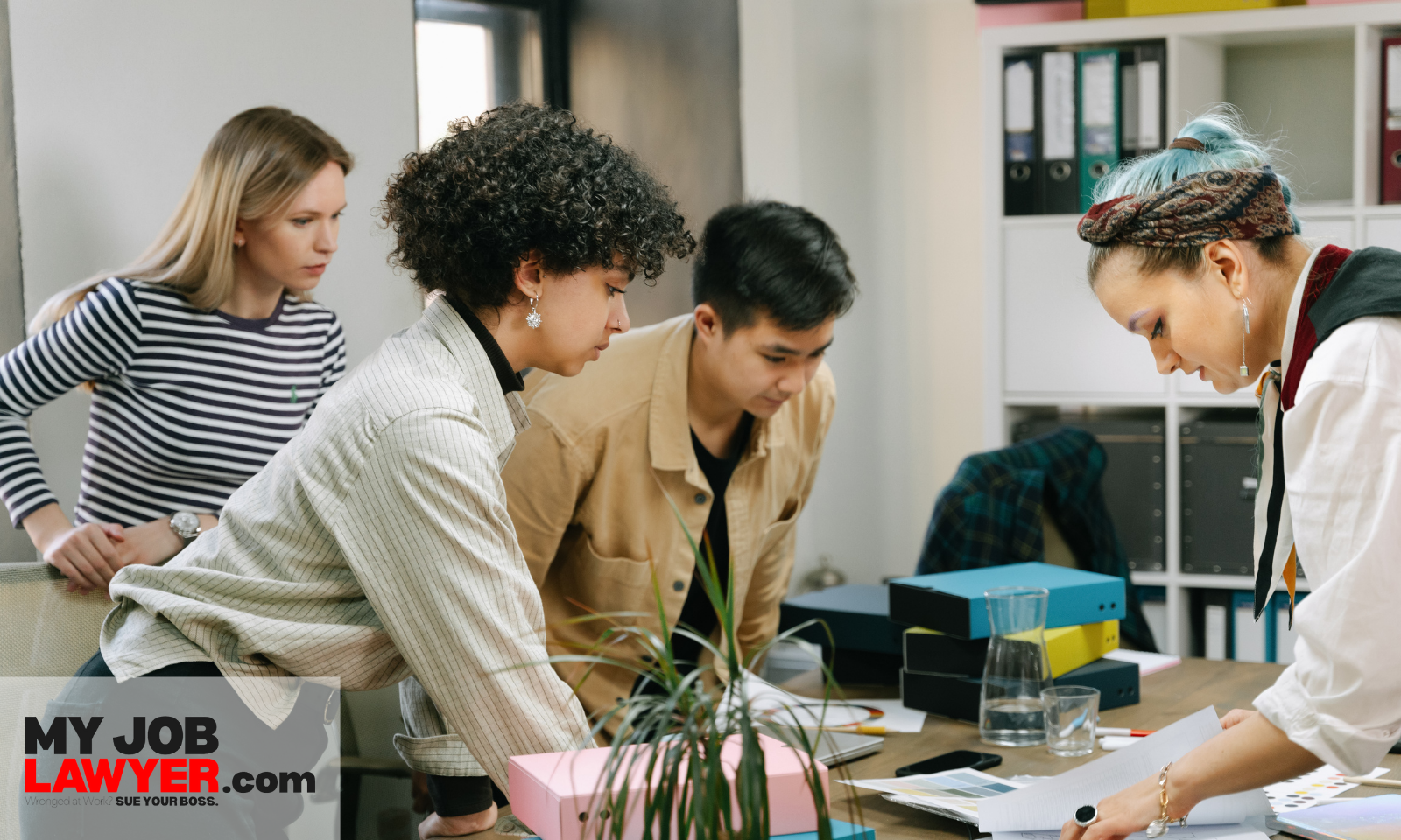 Older employee sitting apart from younger coworkers during a meeting, illustrating age discrimination at work examples in a modern workplace.