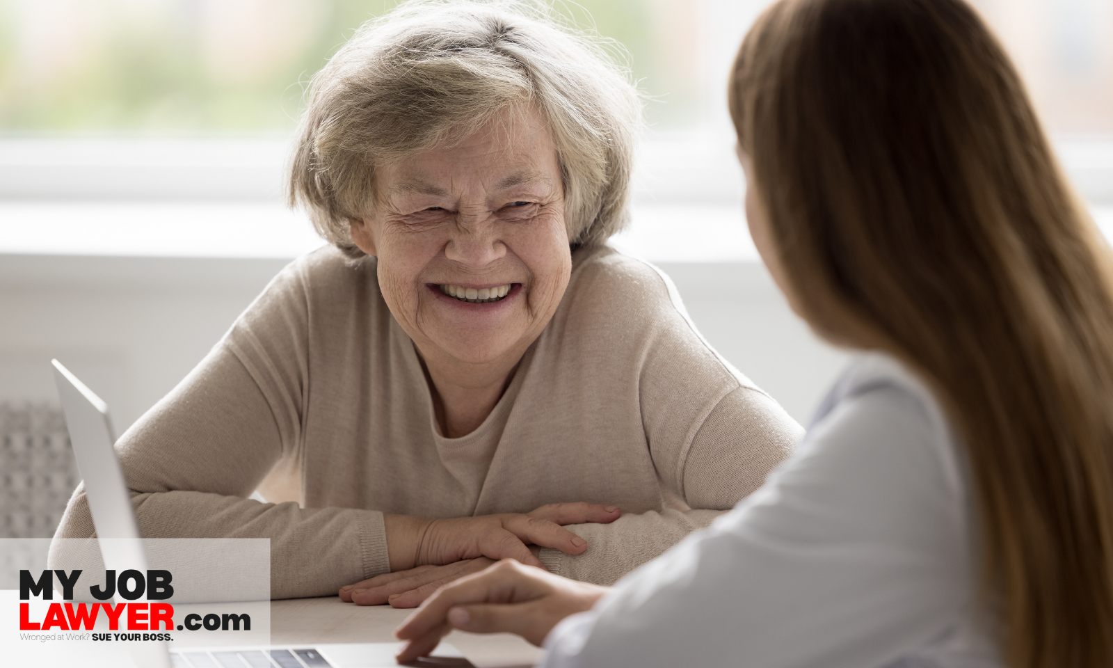 Older worker meeting with an employment lawyer at a desk to discuss age discrimination at work examples and legal options.