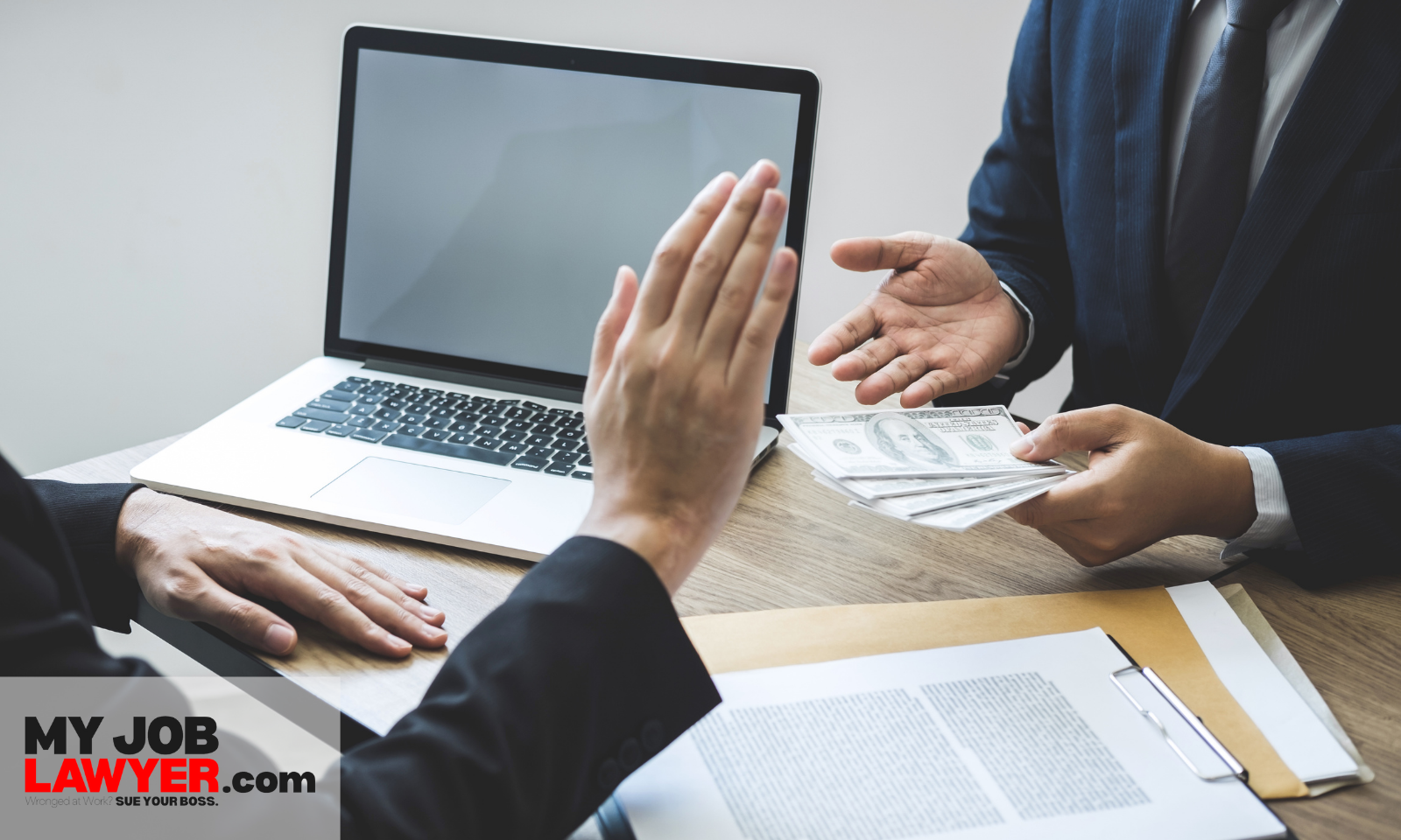 Hands of an employer and employee reviewing an agreement, representing what a breach of employment contract looks like.